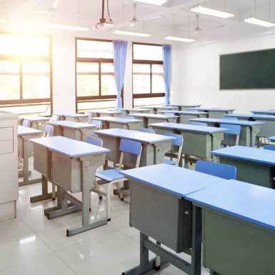 Empty,Classroom,With,Blue,Desks,And,Chairs.